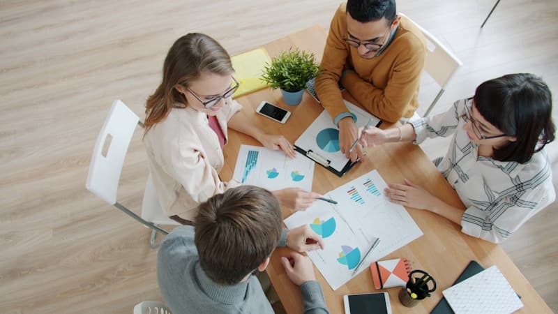 Team collaborating around a table — Photo by Vitaly Gariev on Unsplash